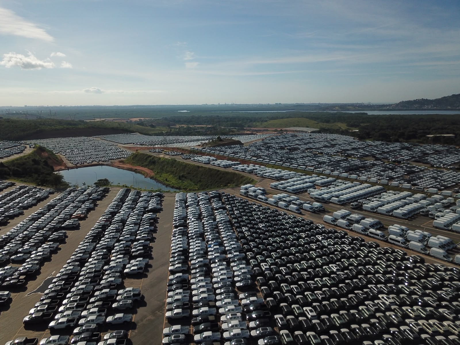 Fotografia real aérea do pátio logístico com grande quantidade de veículos estacionados